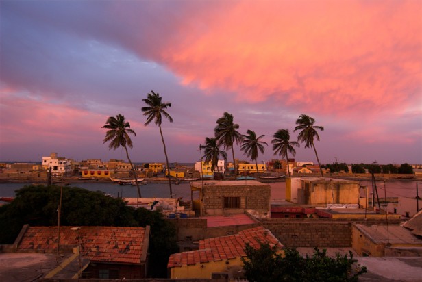 Poranek nad Atlantykiem. Ciepłe, miekkie światło maluje piękną barwą zarówno budynki jak i chmury. To świetny moment na fotografowanie. Senegal, Saint Louis. Poranek nad Atlantykiem. Ciepłe, miekkie światło maluje piękną barwą zarówno budynki jak i chmury. To świetny moment na fotografowanie. Senegal, Saint Louis.